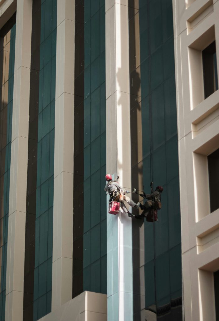 eine Skulptur eines Mannes, der die Seite eines hohen Gebäudes hinaufklettert